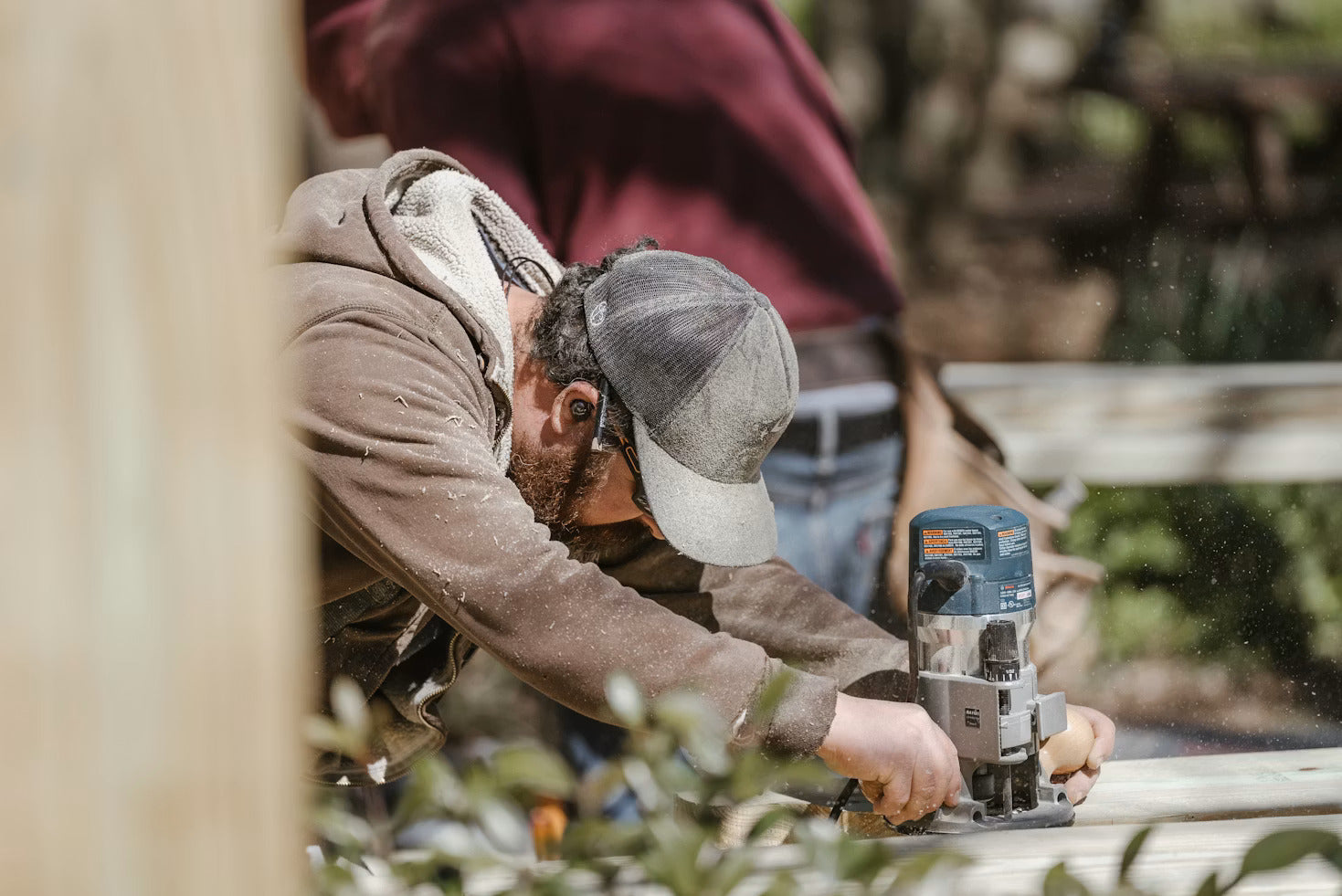 Carpenter drilling a pilot hole into a wood board